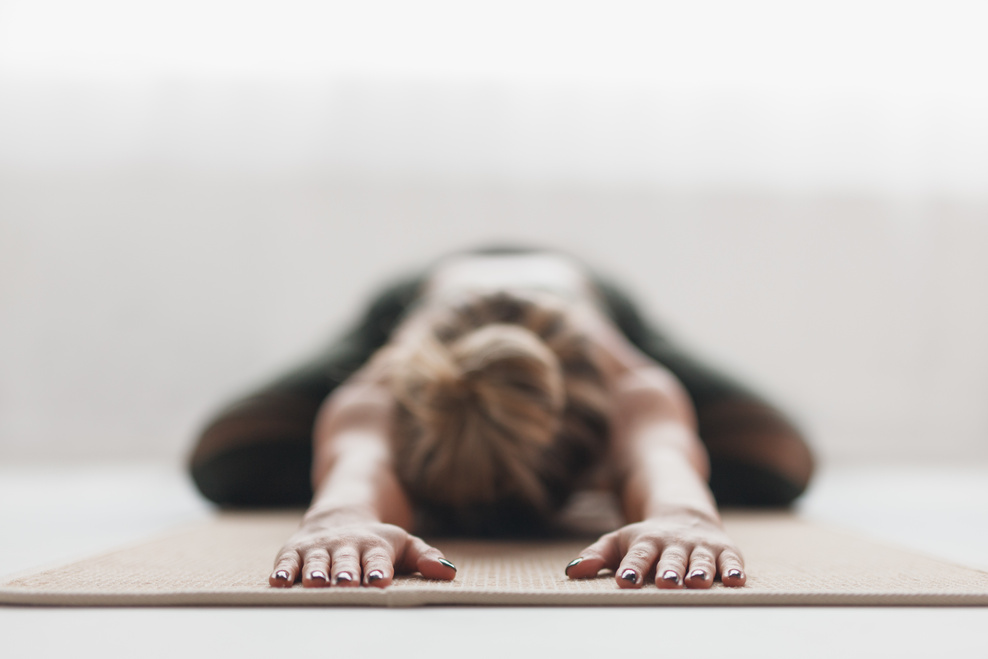 Anonymous stretching woman on mat