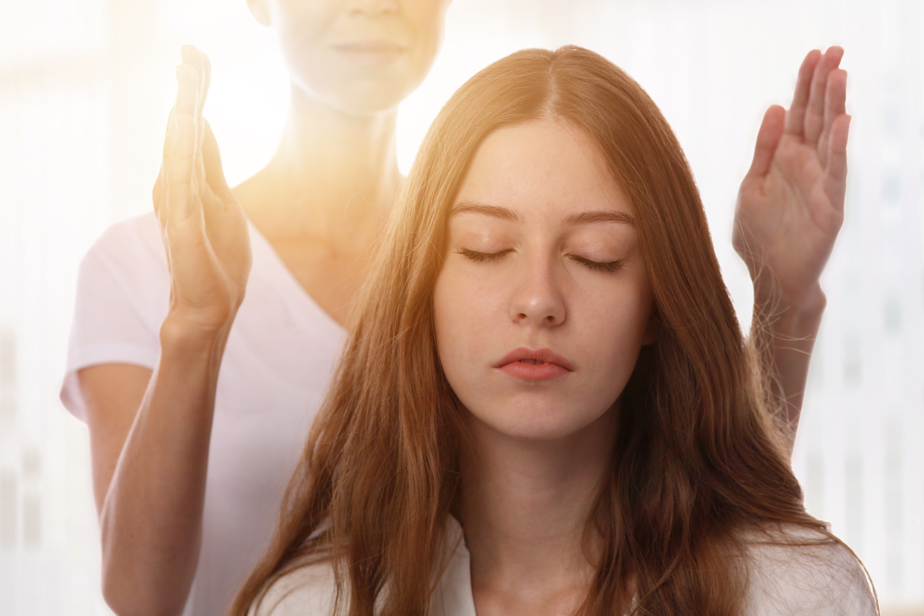 Woman having reiki healing treatment , alternative medicine concept.